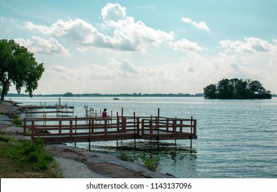A woman sitting at the end of the pier at waterworks park in beaver dam Wisconsin