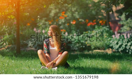 Woman sitting eyes closed enjoy rest smile and relax, spring bloom tree leaf grow well. Inner peace mindset, faith inspire, reiki therapy chakra concept. Skin care protect recovery, organic herb plant