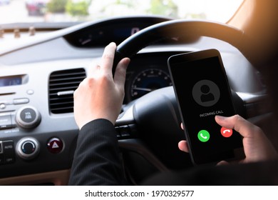 A woman sitting in front of a driver in a car is using a smartphone and appication to drive a motor vehicle to get directions. Press the phone button to call, tell your friend you're on the go.