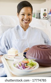 Woman Sitting In Hospital Bed With A Tray Of Food