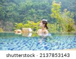 Woman sitting in the hotspring on sunny day