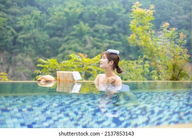 Woman sitting in the hotspring on sunny day