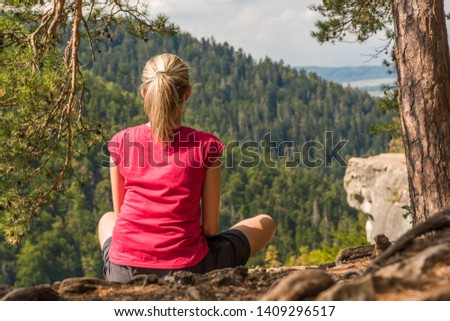 Woman sitting in joga posture looking on mountains