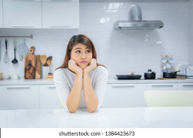 Woman sitting in the kitchen Think of the food menu