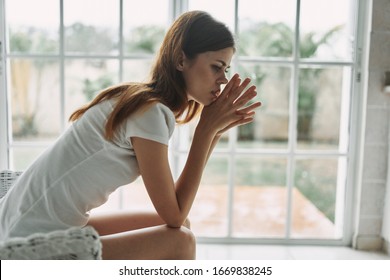 woman sitting near window side view puzzled look