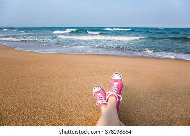 Woman Sitting On The Beach With First Person Perspective View, Legs In Focus