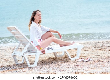 woman sitting on the beach with laptop. young woman relaxing on the beach. 
Beautiful woman on the beach is smeared with sunblock. Rest and relaxation. Travel to the sea