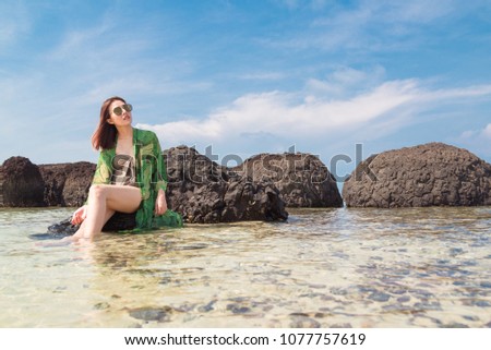 Woman sitting on beach sand and relaxing with blue sky,Happiness Holiday Concept.