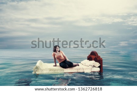 Woman sitting on a bed floating in the ocean.