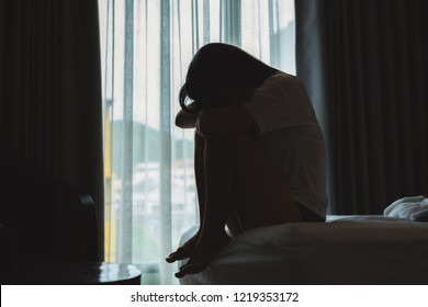 Woman sitting on the bed, head down, she seemed Lonely and sad - Shutterstock ID 1219353172