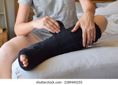 Woman Sitting On Bed Putting On Night Compression Wrap On Lymphedema Affected Leg