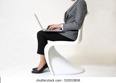 Woman Sitting On A Chair And Typing With Laptop Side View