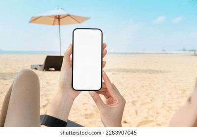 Woman sitting on deckchair on the beach with hand holding smartphone mockup of blank screen, Take your screen to put on advertising. Summer vacation concept. - Powered by Shutterstock