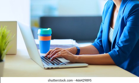 Woman Sitting On The Desk With Laptop.