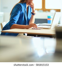 Woman Sitting On The Desk With Laptop.