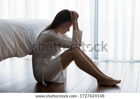 Woman sitting on floor feels unhappy by personal problems, break up or ruined marriage, unwilling pregnancy regret about abortion decision, chronic insomnia sleep disorder, alcohol dependence concept