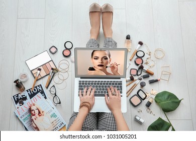 Femme assise sur le sol avec un ordinateur portable et regardant la formation en ligne pour un maquilleur professionnel