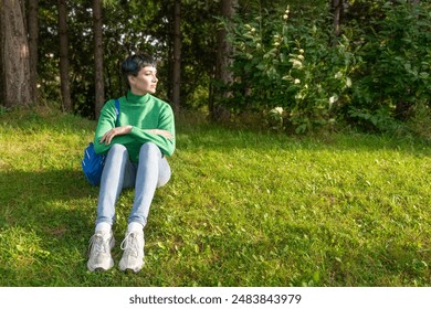 Woman Sitting on Grass in Park on Sunny Day - Powered by Shutterstock