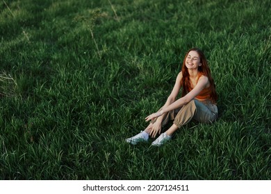 Woman sitting on green grass in nature in a park, view from above - Powered by Shutterstock