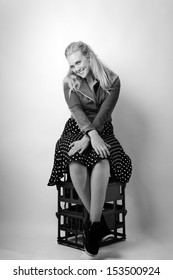 Woman Sitting On Milk Crates Shot In The Studio On White Background