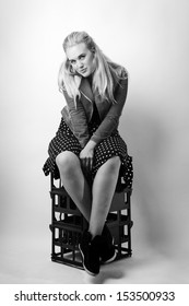 Woman Sitting On Milk Crates Shot In The Studio On White Background