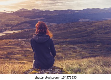 Woman sitting on mountain top and contemplating the sunset - Shutterstock ID 154578533