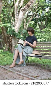 Woman Sitting On Old Bench,reading Book,hobby On Holiday,in A Park