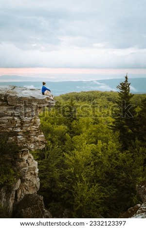 Woman sitting on a rock's edge at Bear Rocks Preserve in the Dolly Sods Wilderness, West Virginia