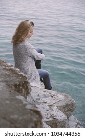 Woman sitting on seacoast 
