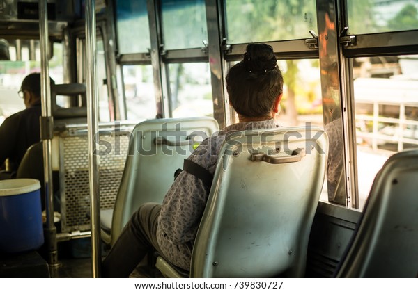 A woman sitting on seat in\
public transportation bus. - Bangkok, Thailand, 22 October\
2017.