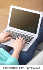 Woman sitting on sofa with a laptop in a room - Shutterstock ID 379552672