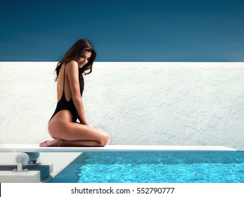 Woman Sitting On Springboard At The Pool