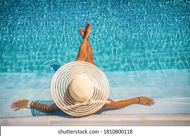 mujer sentada en las escaleras de una lujosa piscina balneario de 5 estrellas. 