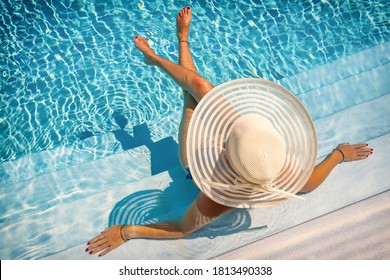 Woman Sitting On The Stairs Of A Luxury Five Stars  Spa Resort  Swimming Pool. 