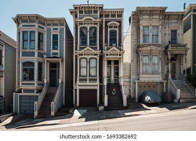 Woman Sitting On The Stairs Of A Traditional San Francisco House In Haight-Ashbury.