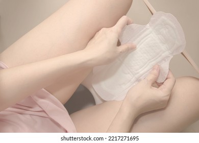 Woman sitting on the toilet bowl and change sanitary napkins. time and cycle to change sanitary for a cleanness and health. - Shutterstock ID 2217271695