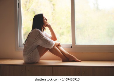 Woman Sitting On The Window Sill