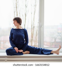 
Woman sitting on a windowsill in sportswear

