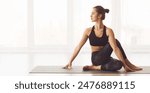 A woman is sitting on a yoga mat, engaging in a yoga pose. She appears focused and balanced, deeply immersed in practice. The setting is simple, with the woman body positioned gracefully on the mat.