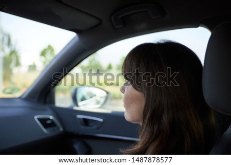 woman sitting in the passenger seat of a car while traveling