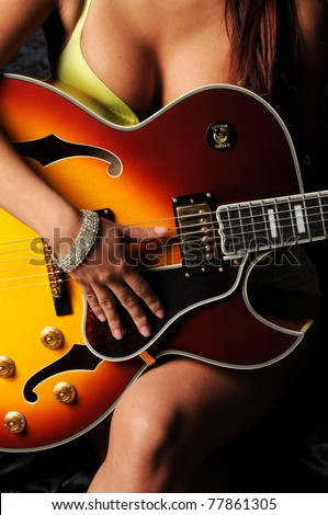Woman sitting playing electric acoustic guitar