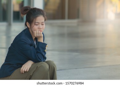 A Woman Sitting In A Sad Face In Front Of The Mall After Lay Off