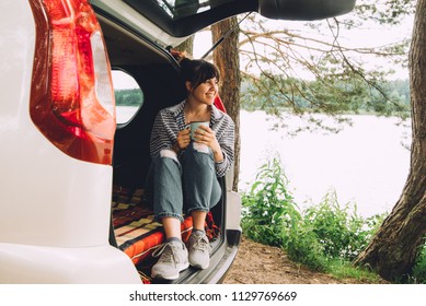 Woman Sitting In Suv Trunk. Car Travel Concept. Summer Time