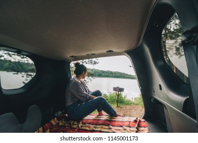 Woman Sitting In Suv Trunk. Car Travel Concept. Summer Time