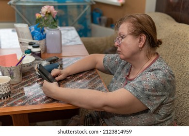 Woman sitting at the table and looking at the smartphone