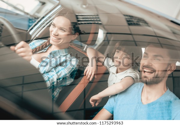 A\
Woman Is Sitting At The Wheel Of A New Vehicle. Young Family. Car\
Buying In A Showroom. Automobile Salon. Cheerful Driver. Happy\
Together. Successful Buying. Good Mood. Great\
Trade.
