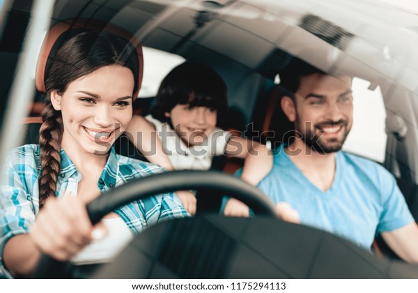 A\
Woman Is Sitting At The Wheel Of A New Vehicle. Smiling Family. Car\
Buying In A Showroom. Automobile Salon. Cheerful Driver. Happy\
Together. Successful Buying. Good Mood. Great\
Trade.