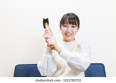 Woman Sitting And Wielding A Hammer