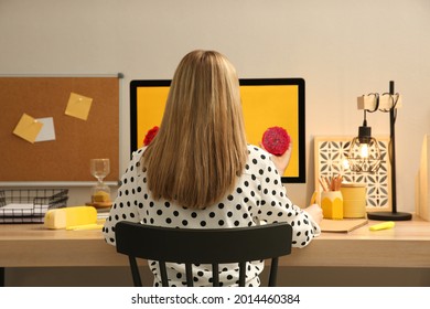 Woman Sitting At Wooden Desk With Computer Near Light Wall, Back View. Interior Design