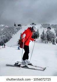 Woman At The Ski Resort With Her Skis Wearing A Pink Jacket.